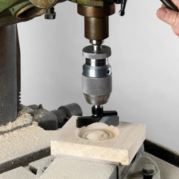 Rosettborr monterad i pelarborrmaskin som borrar ett runt urtag i trä – exakt håltagning för tappförband och snickeriarbete.